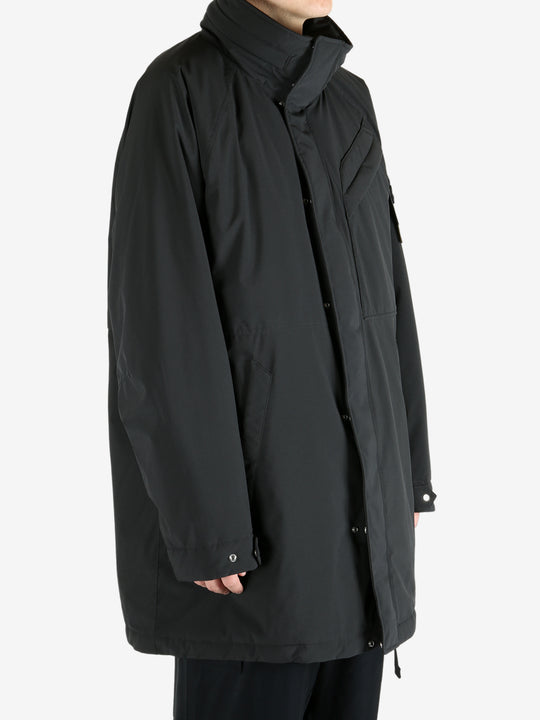 Black coat worn by a person, showing the coat fit