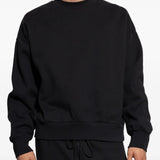 Black sweatshirt worn by a person, showing the sweatshirt's fit