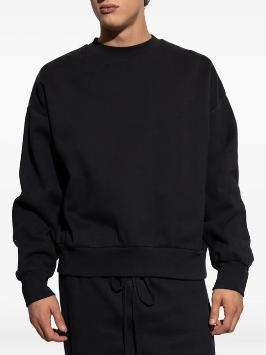 Black sweatshirt worn by a person, showing the sweatshirt's fit