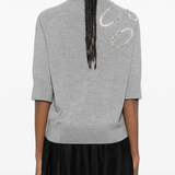 Grey sweater worn by a person, showing the sweater's fit