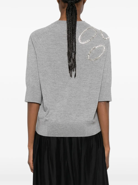 Grey sweater worn by a person, showing the sweater's fit