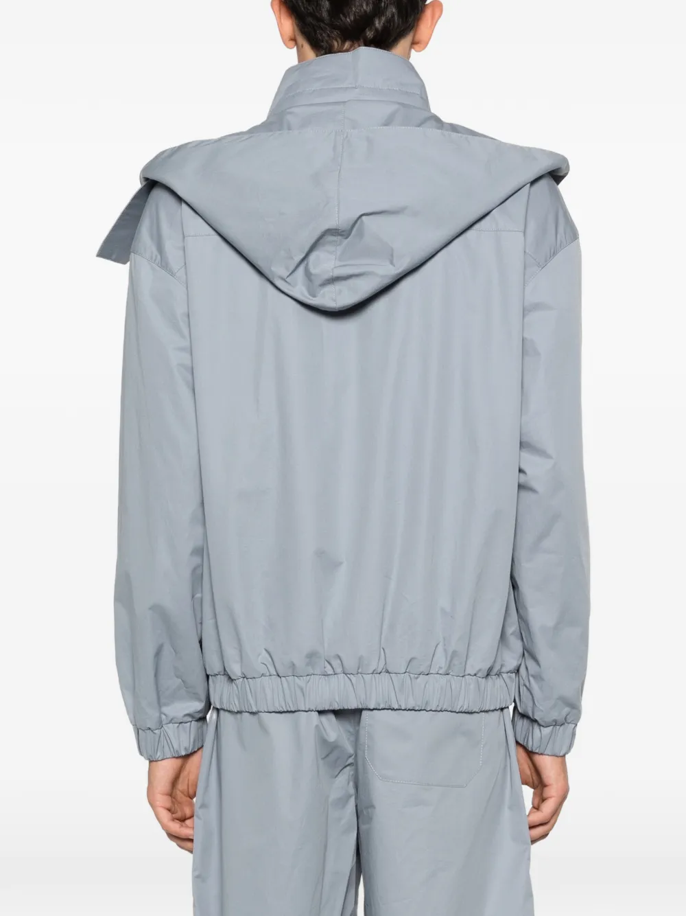 Grey windbreaker worn by a person, showing the windbreaker fit