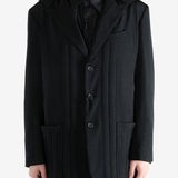 Black coat worn by a person, showing the coat fit