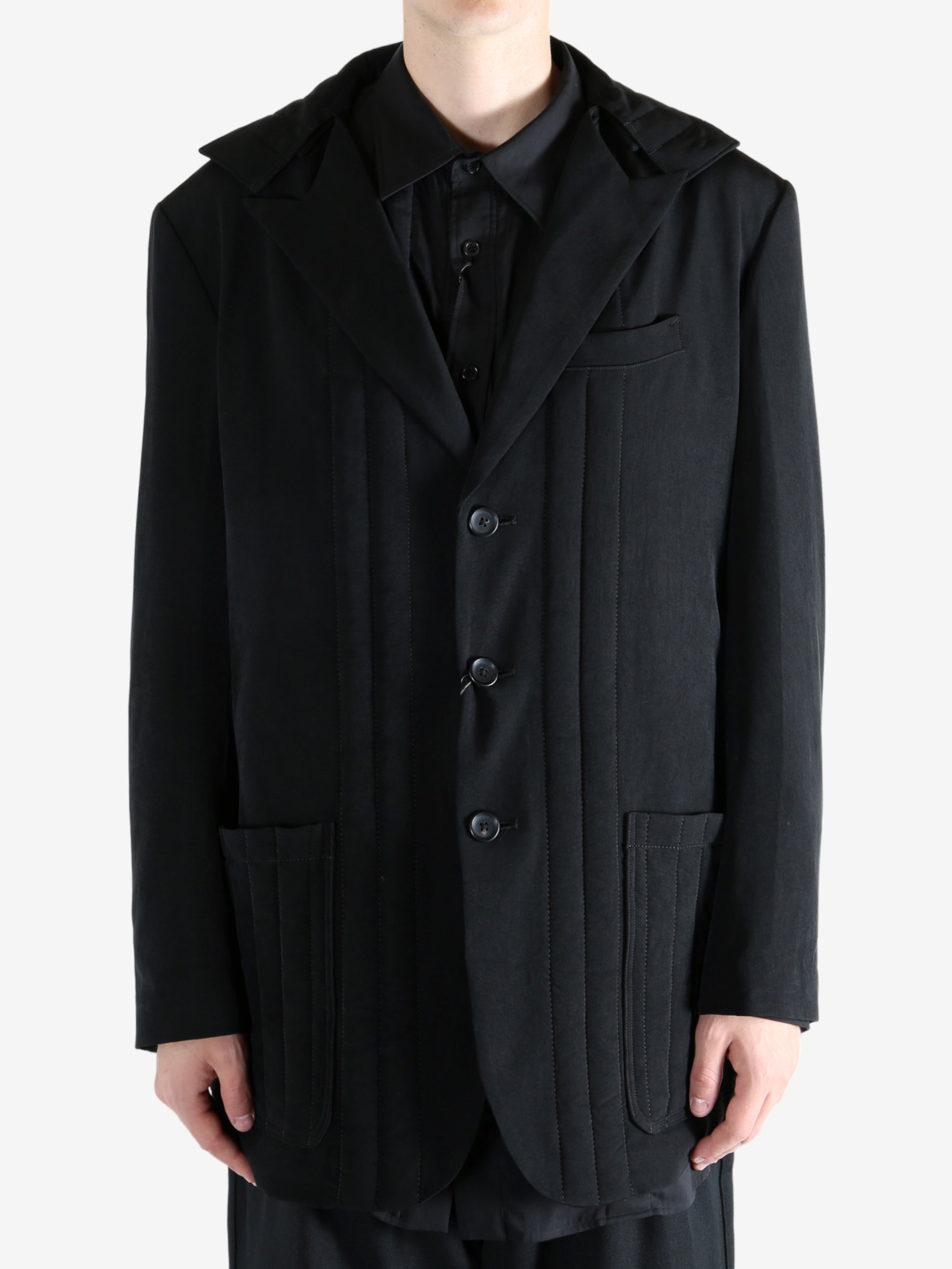 Black coat worn by a person, showing the coat fit