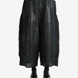 Black pants worn by a person, showing the pants' fit