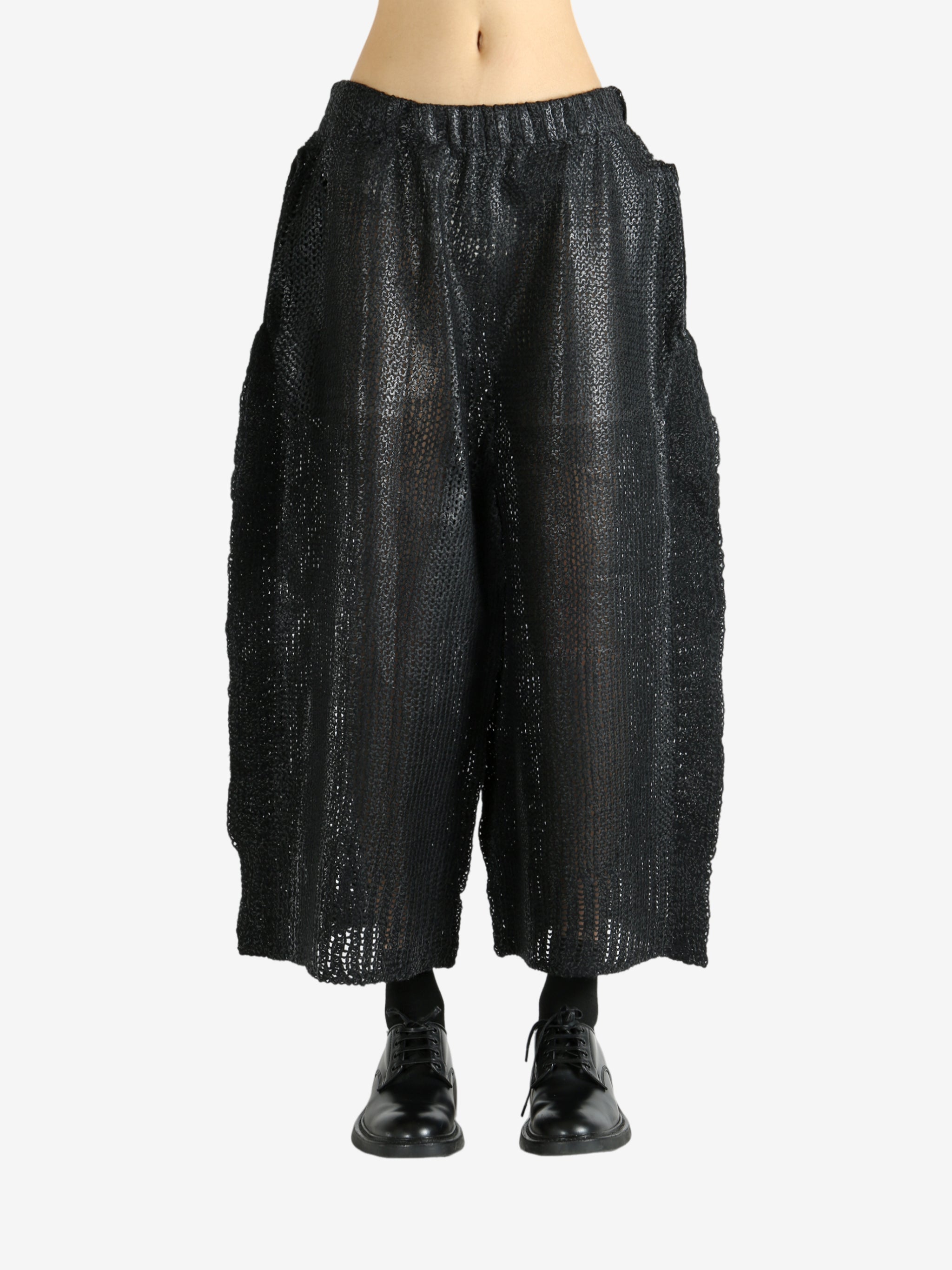 Black pants worn by a person, showing the pants' fit