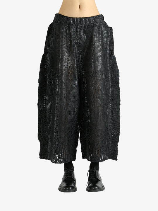 Black pants worn by a person, showing the pants' fit