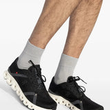 Black sneaker worn by a person, showing the sneaker's fit