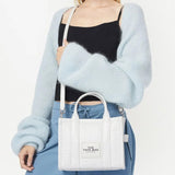 White bag carried by a person, showing the bag's fit