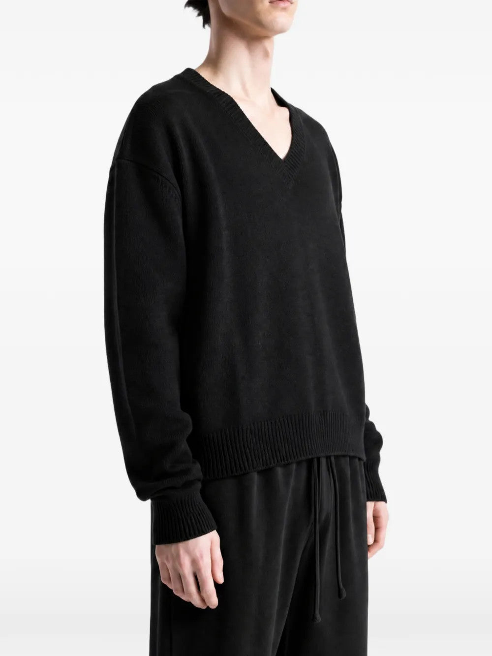 Black knitwear worn by a person, showing the knitwear fit