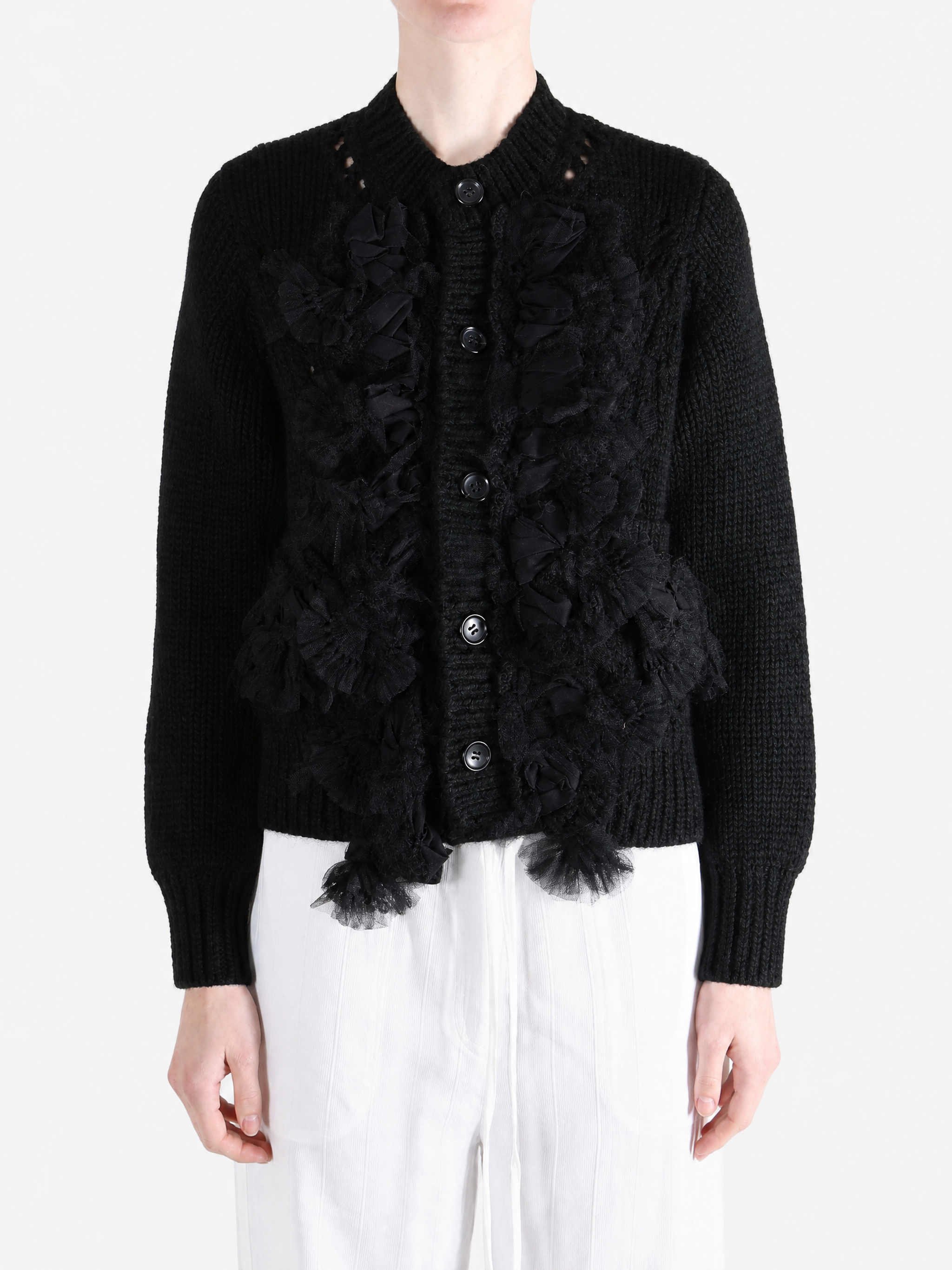 Black knitwear worn by a person, showing the knitwear fit