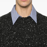 Close up of black knitwear, showing texture of the wool fabric