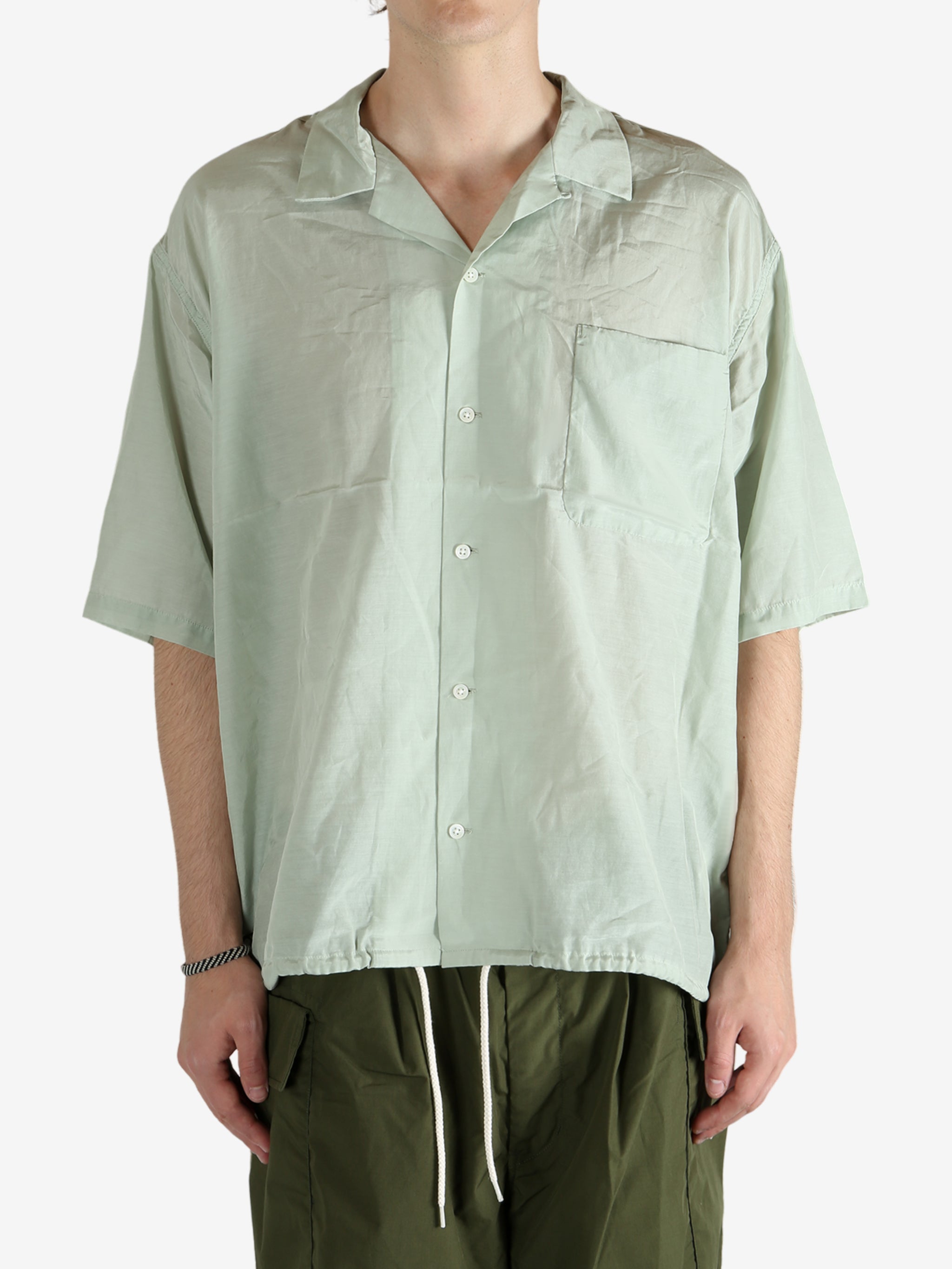 Green shirt worn by a person, showing the shirt's fit