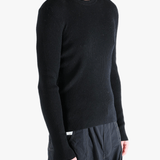 Black sweater worn by a person, showing the sweater fit