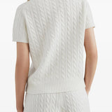 White knitwear worn by a person, showing the knitwear's fit