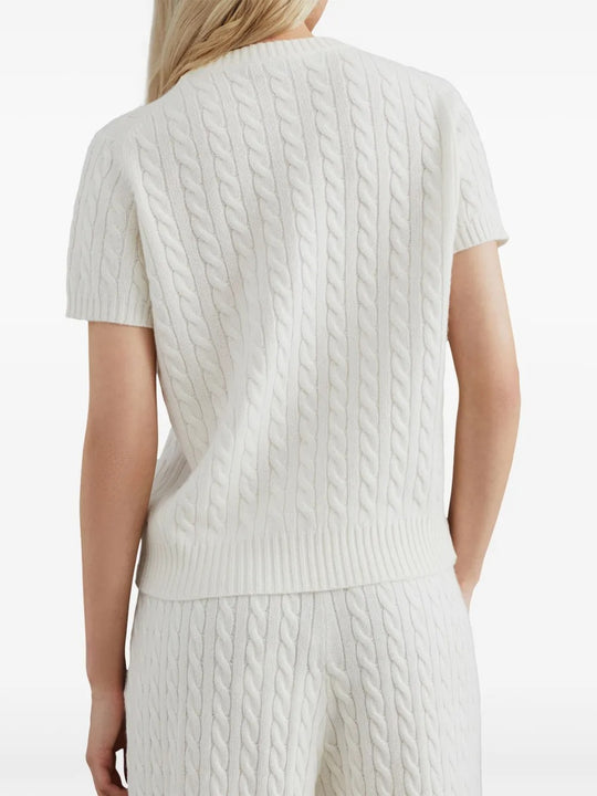 White knitwear worn by a person, showing the knitwear's fit