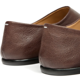 Close up of the brown shoes, showing texture of the leather fabric