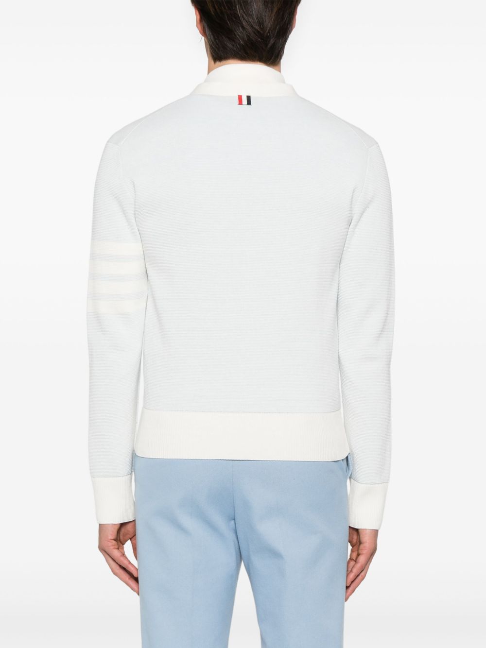 Blue knitwear worn by a person, showing the knitwear’s fit