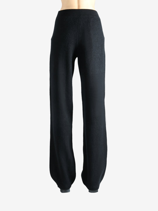 Black pants worn by a person, showing the pants' fit