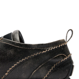 Close up of the brown shoes, showing texture of the leather fabric