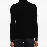 Black knitwear worn by a person, showing the knitwear fit