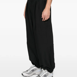 Black pants worn by a person, showing the pants fit