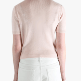 Pink knitwear worn by a person, showing the knitwear's fit