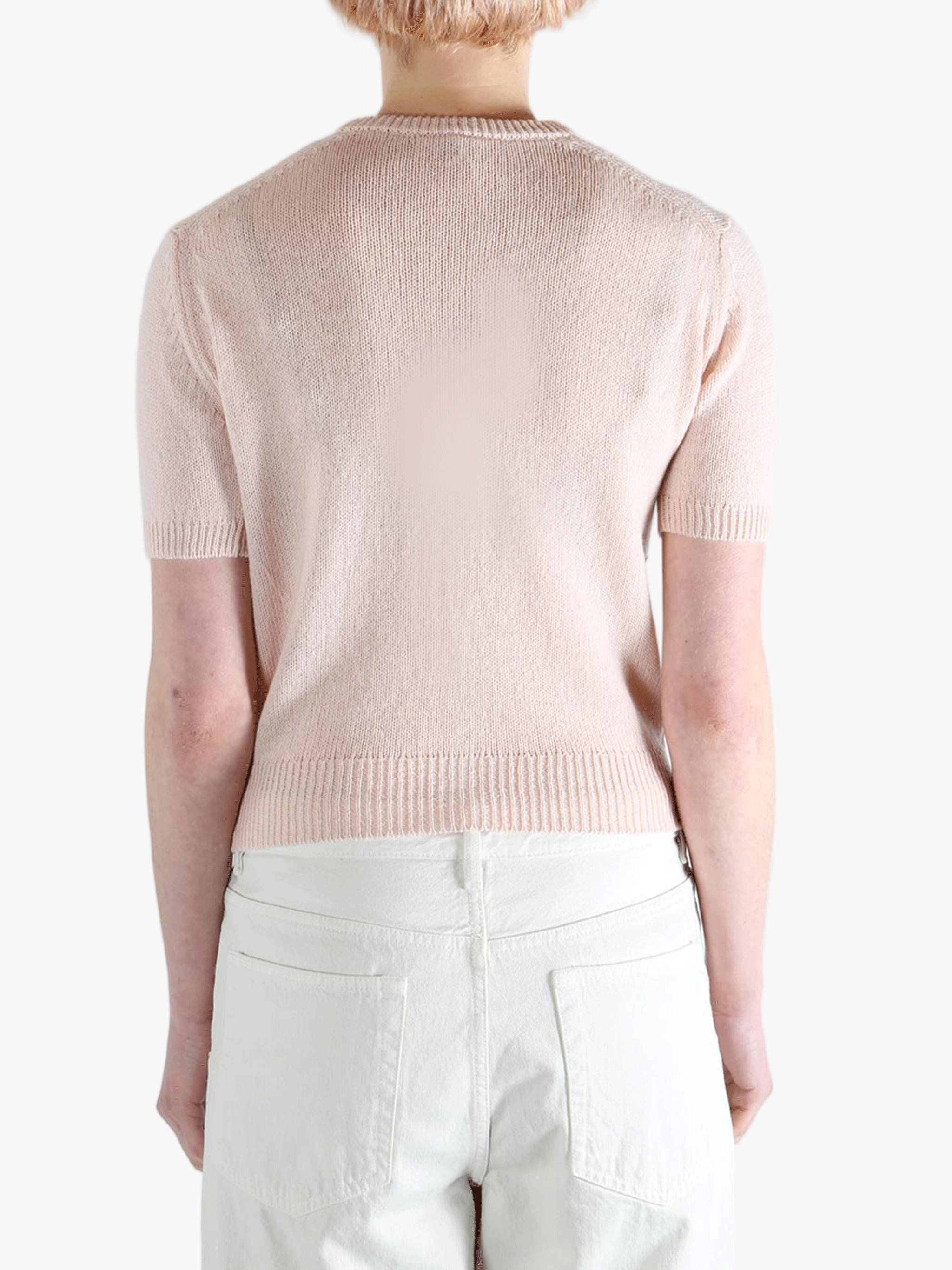 Pink knitwear worn by a person, showing the knitwear's fit