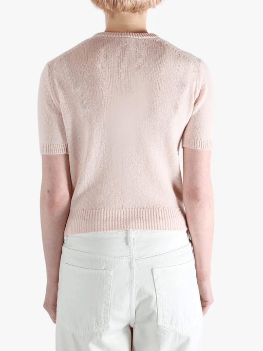 Pink knitwear worn by a person, showing the knitwear's fit