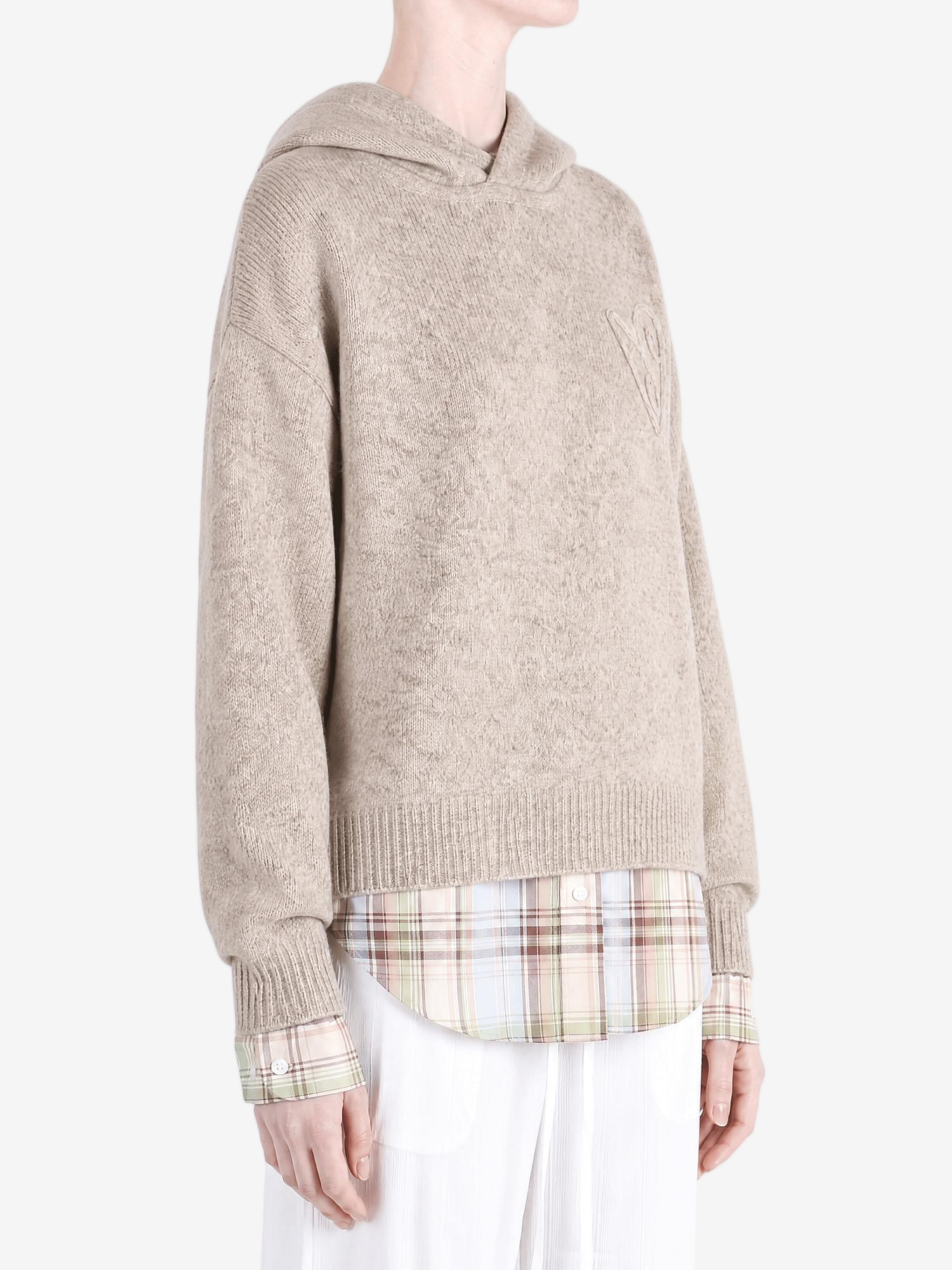 Tan knitwear worn by a person, showing the knitwear fit