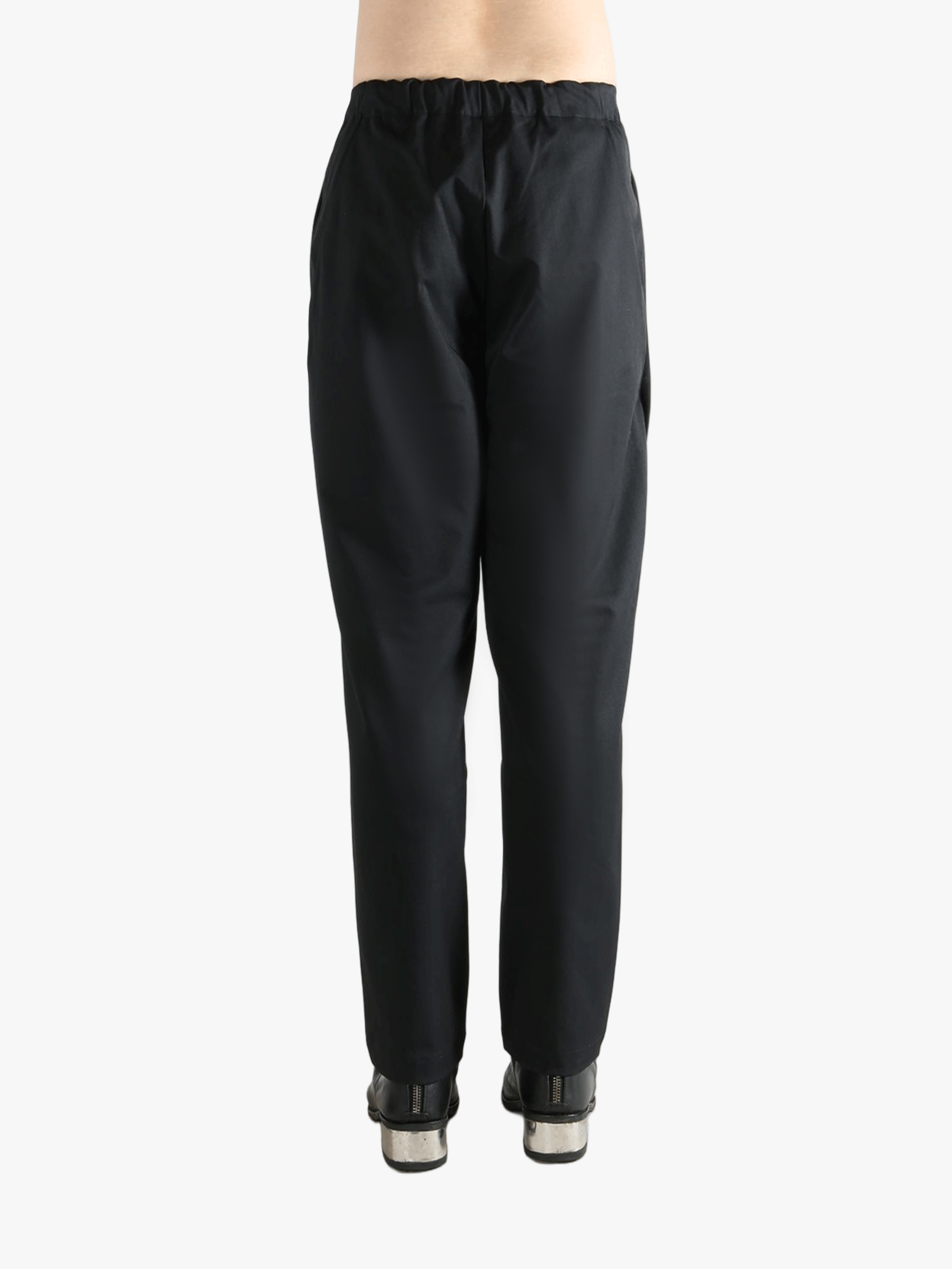 Black pants worn by a person, showing the pants' fit