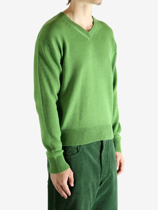 Green knitwear worn by a person, showing the knitwear's fit