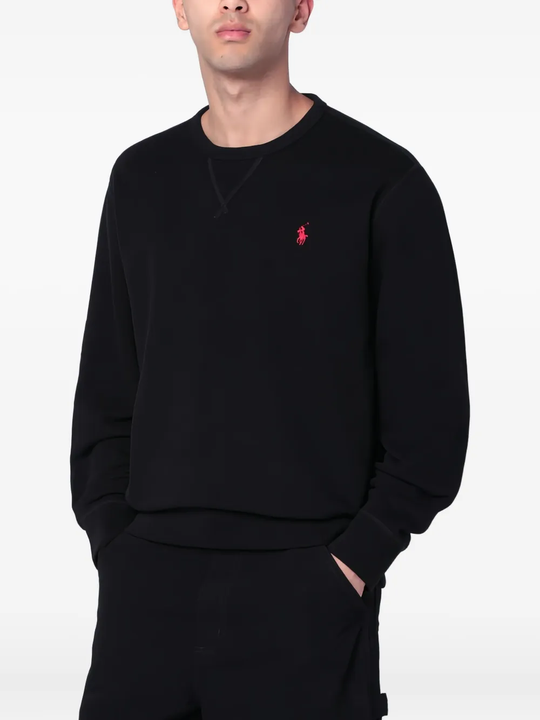 Black sweatershirt worn by a person, showing the sweatershirt's fit