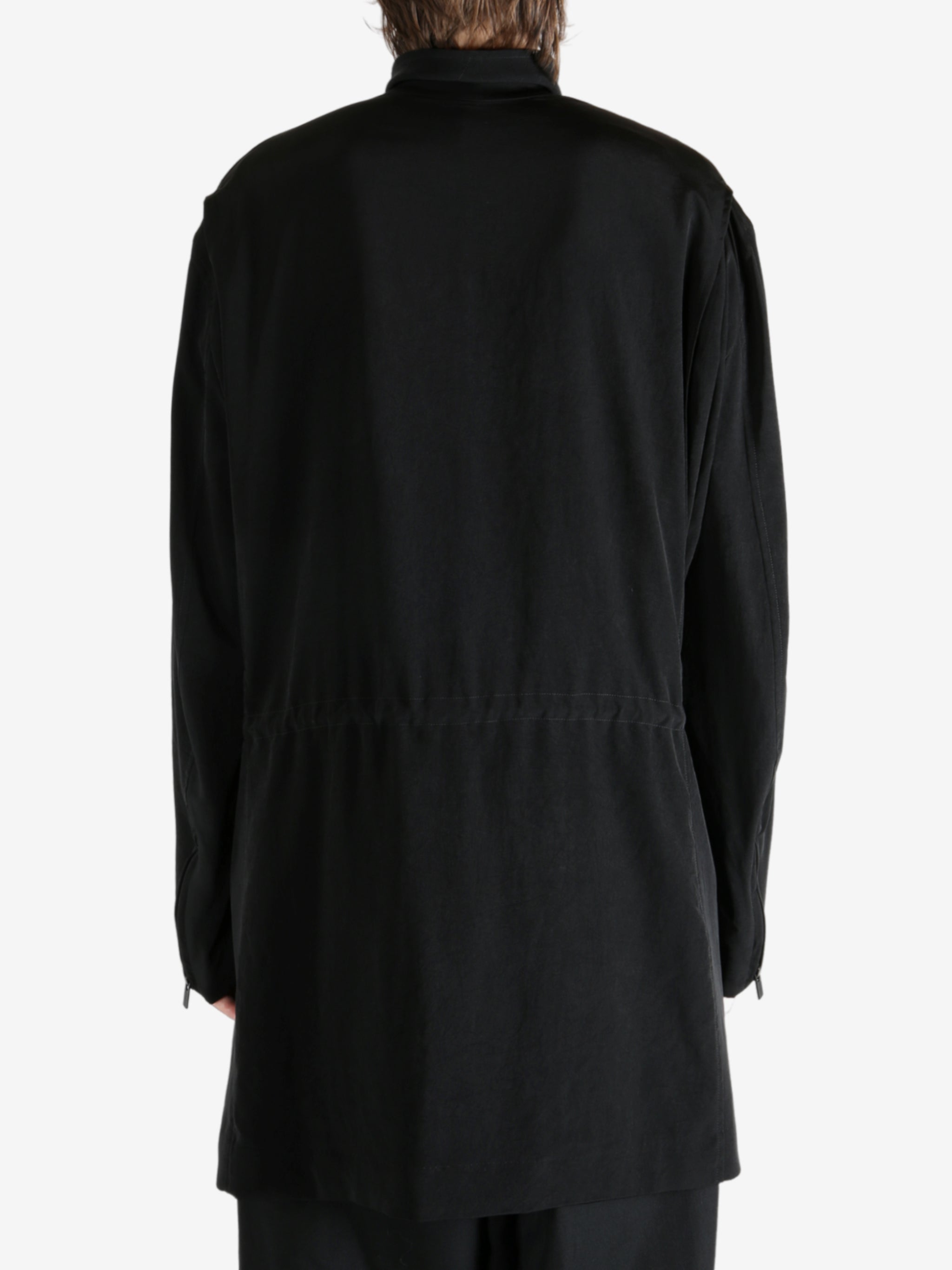 Black coat worn by a person, showing the coat fit