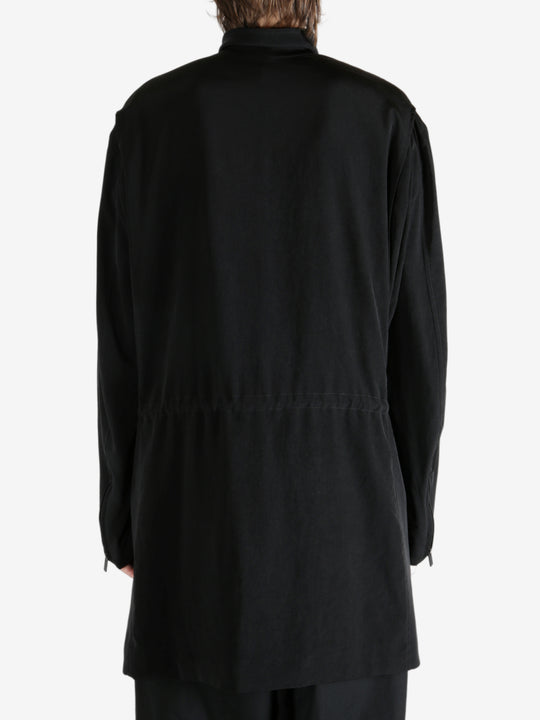 Black coat worn by a person, showing the coat fit