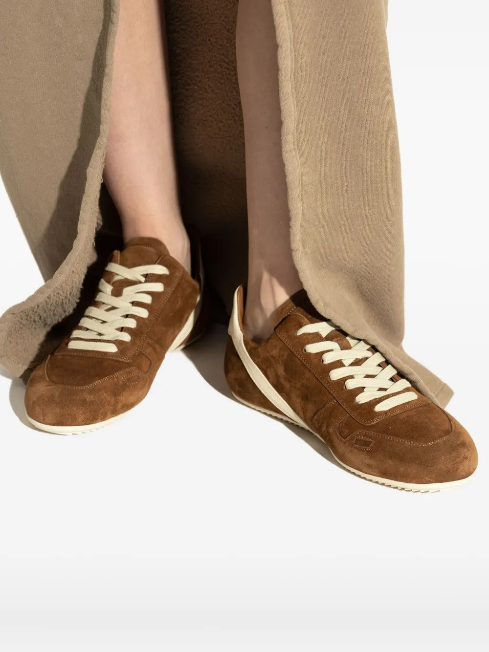 Brown sneakers worn by a person, showing the sneakers' fit
