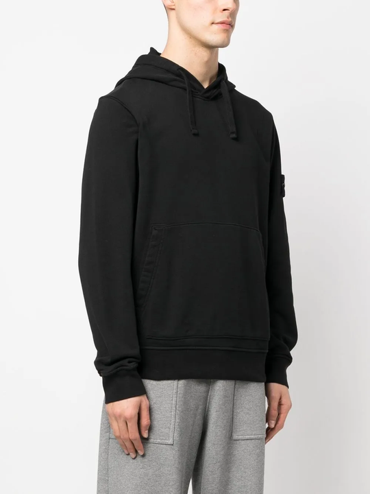Black sweater worn by a person, showing the sweater's fit