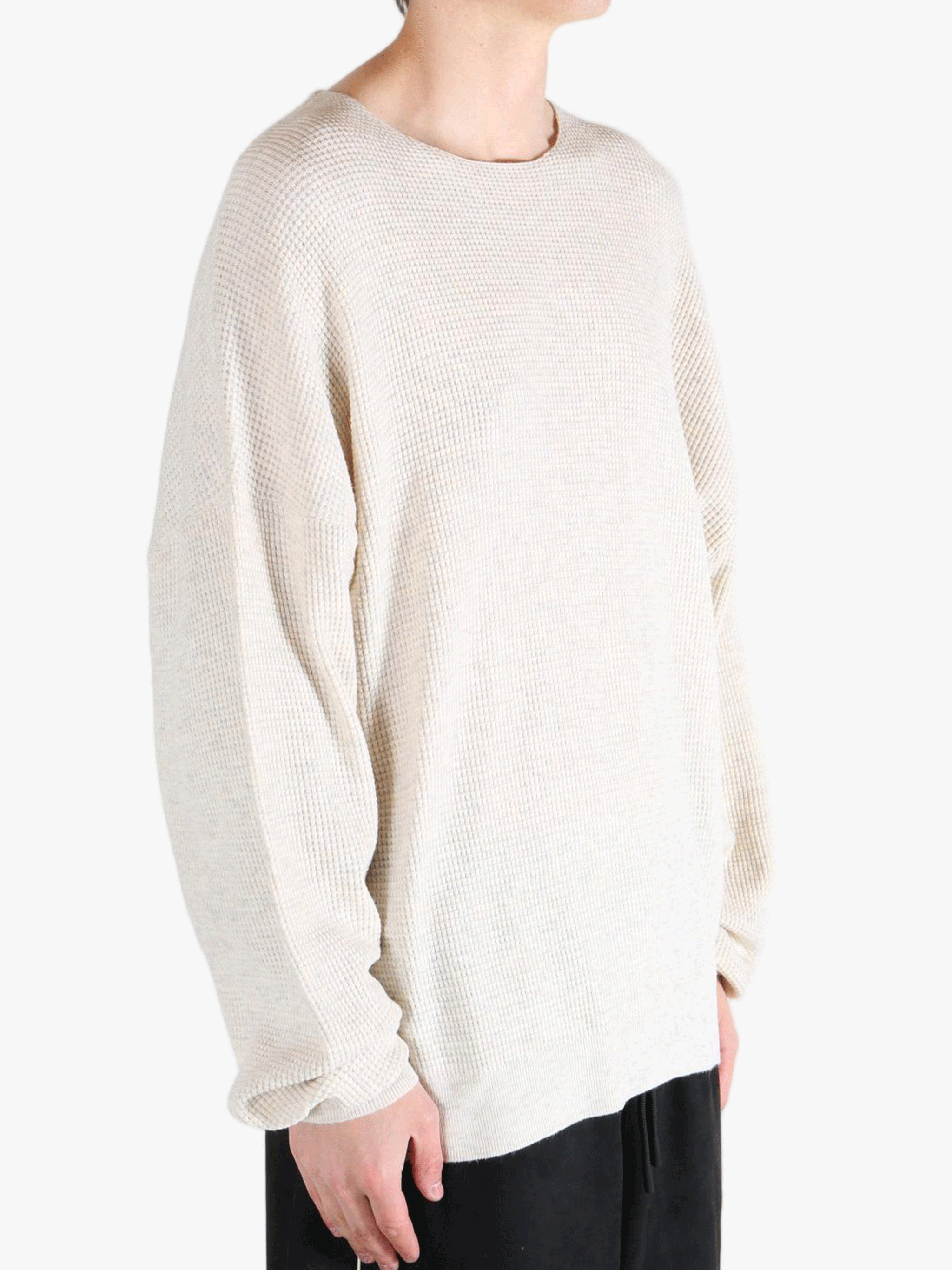 White sweater worn by a person, showing the sweater's fit