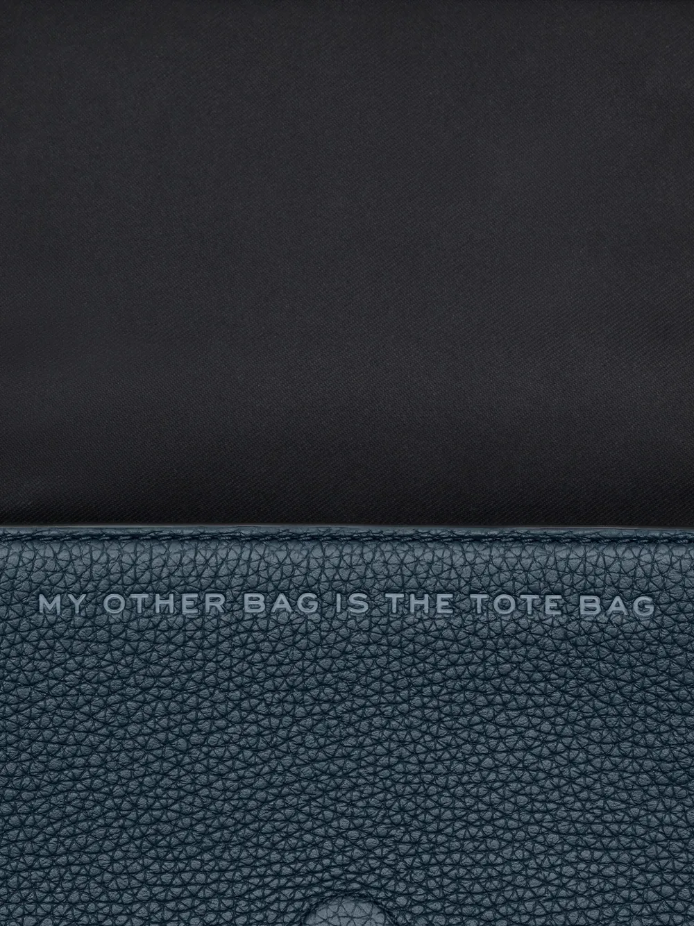 Close up of the navy bag, showing texture of the leather fabric