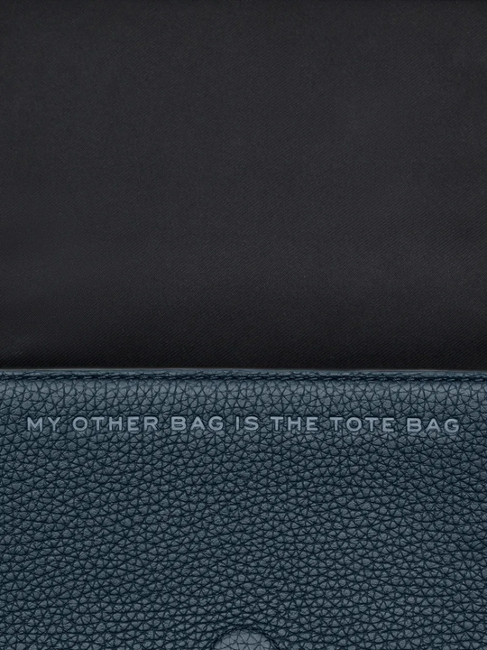 Close up of the navy bag, showing texture of the leather fabric