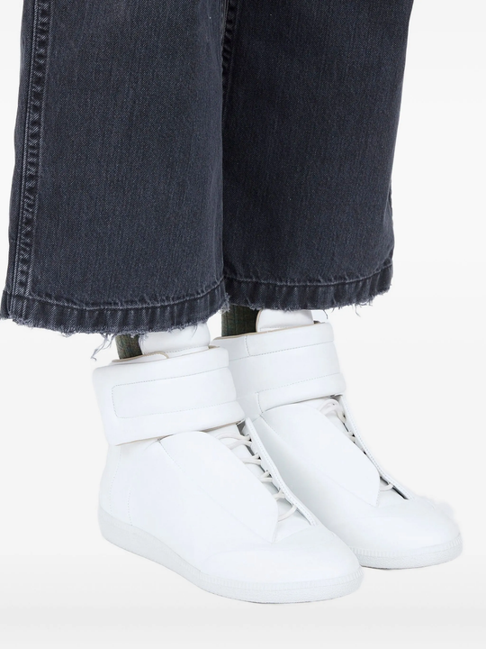 white sneakers worn by a person, showing the sneakers fit