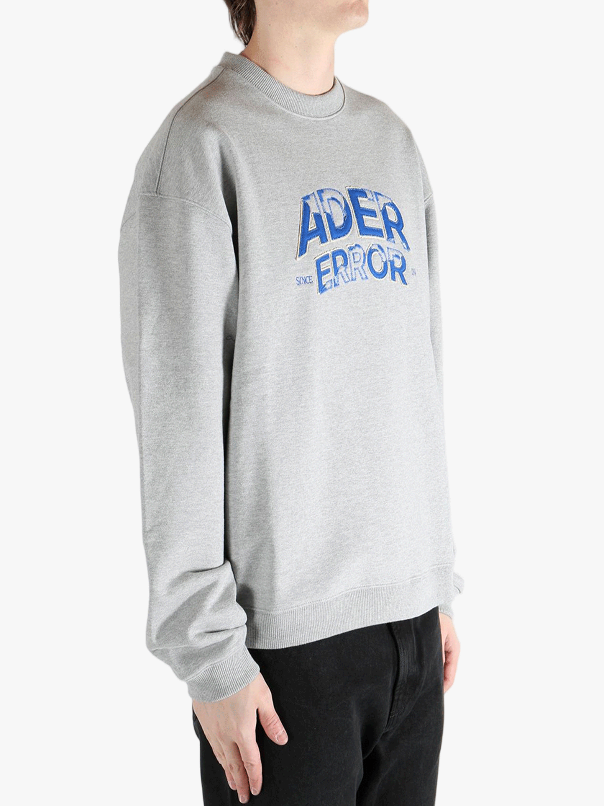 Grey sweater worn by a person, showing the sweater's fit