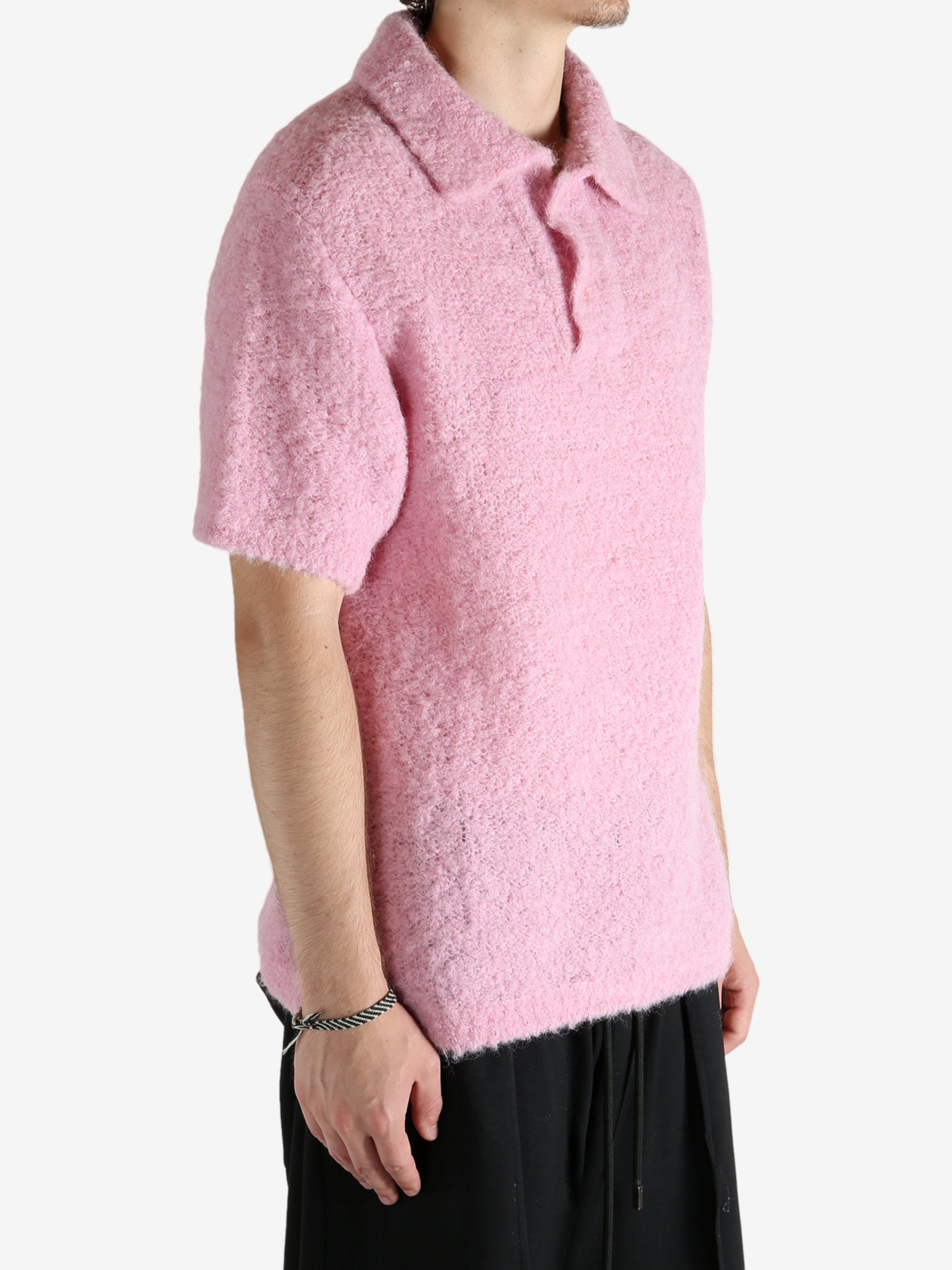 Pink knitwear worn by a person, showing the knitwear's fit