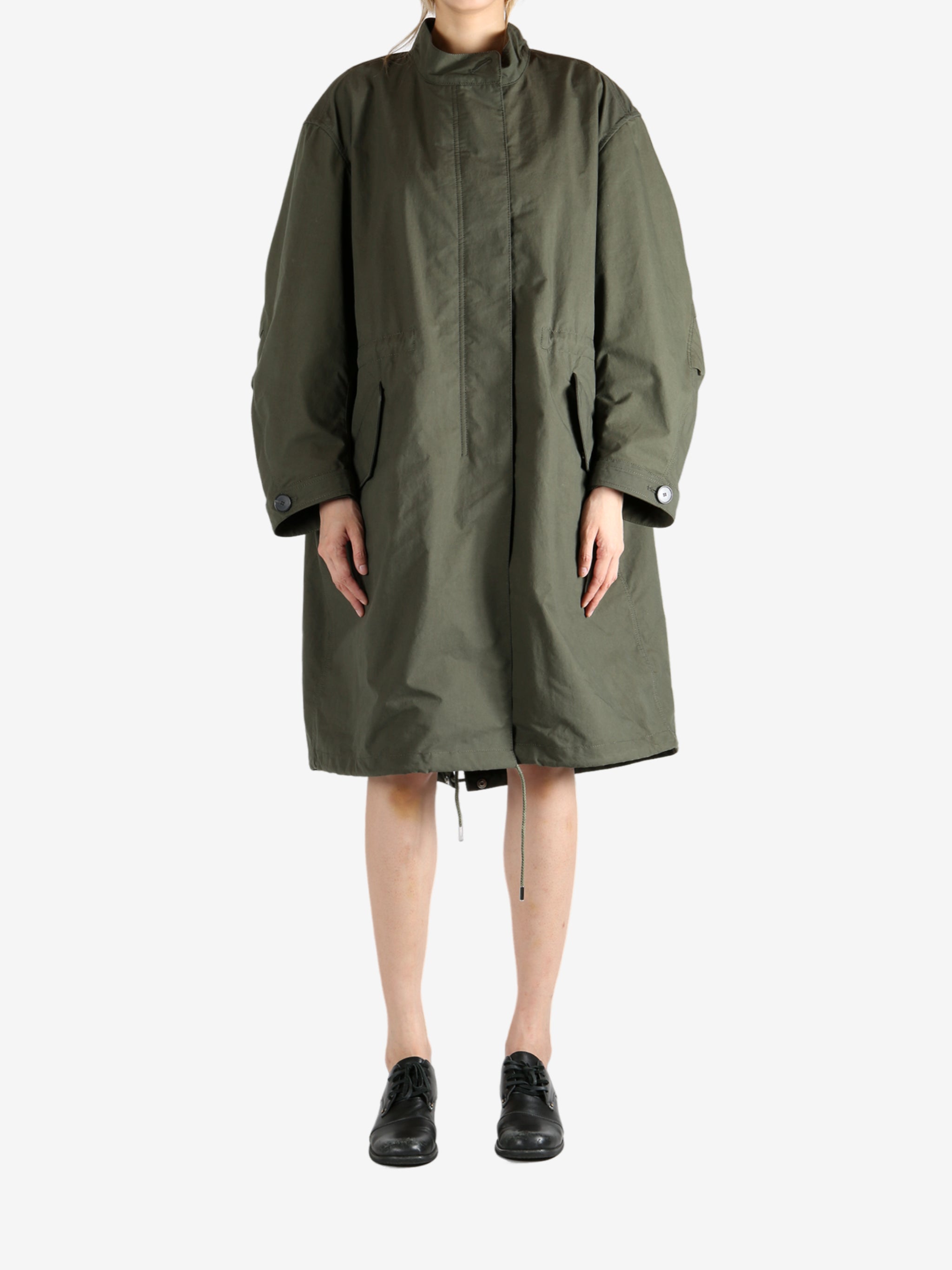 Green coat worn by a person, showing the coat fit