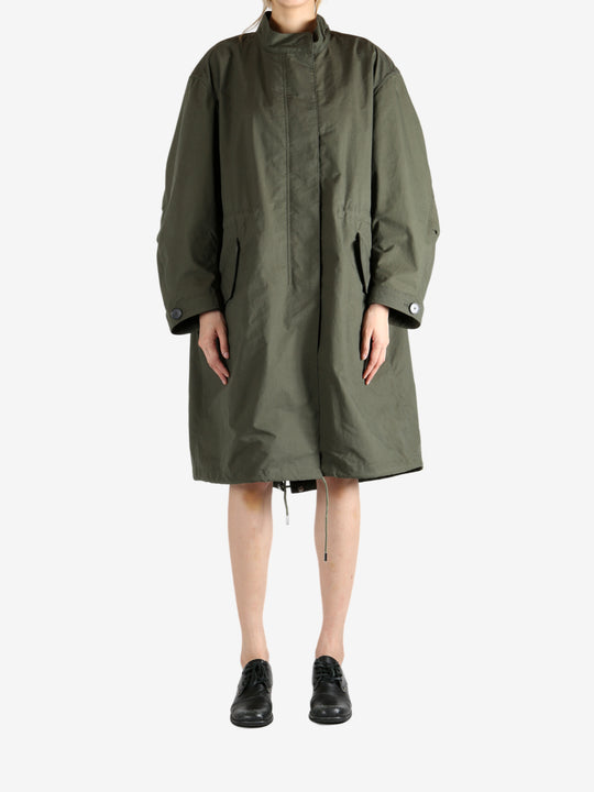 Green coat worn by a person, showing the coat fit