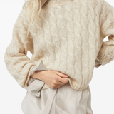 Tan knitwears worn by a person, showing the knitwears fit