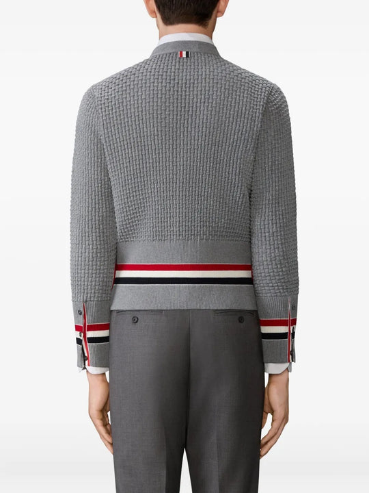 Grey knitwear worn by a person, showing the knitwear fit