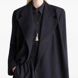 Black coats worn by a person, showing the coats fit