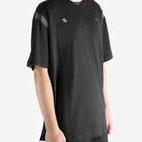 Black tee worn by a person, showing the tee"s fit