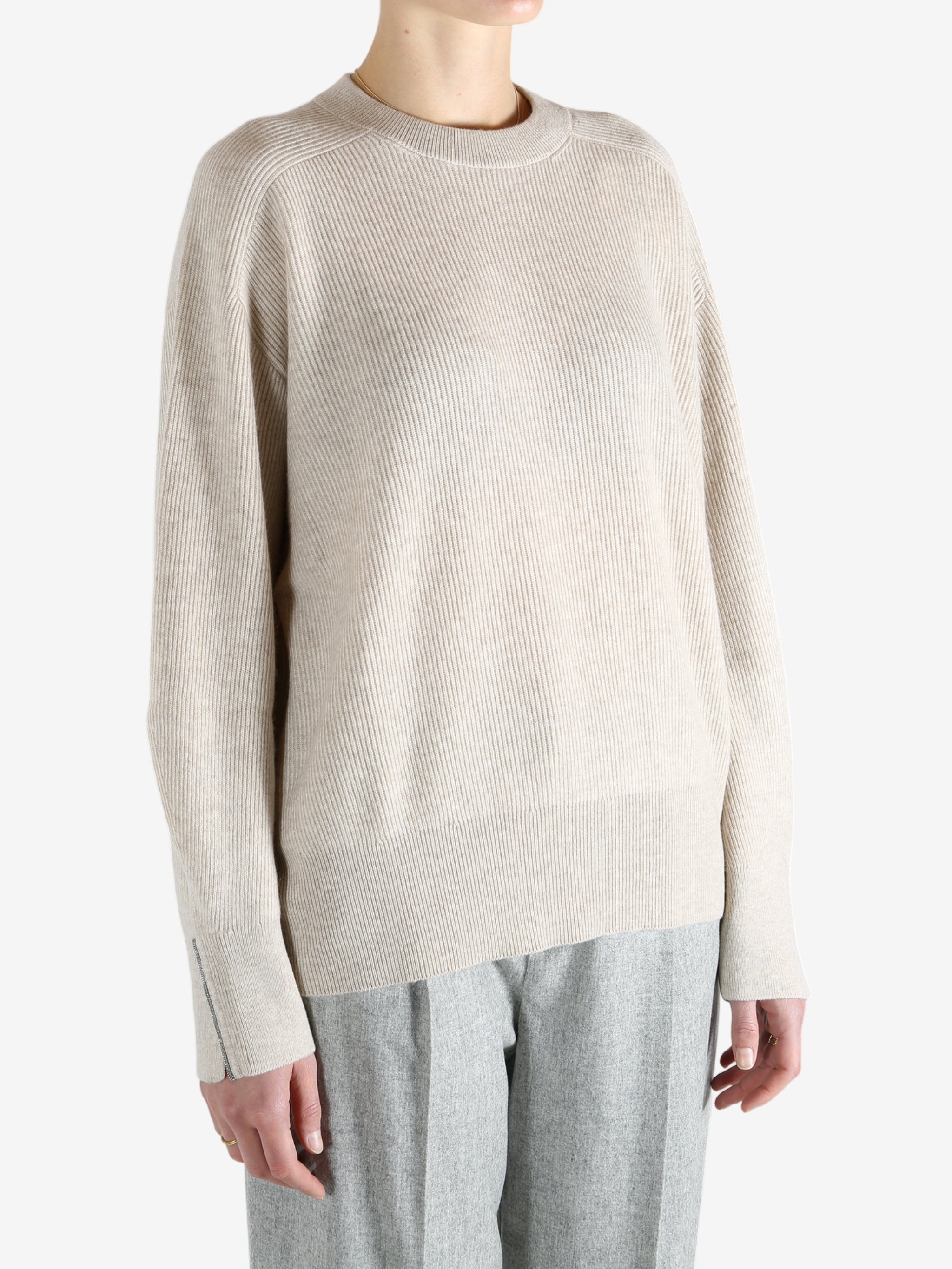 Grey knitwear worn by a person, showing the knitwear fit